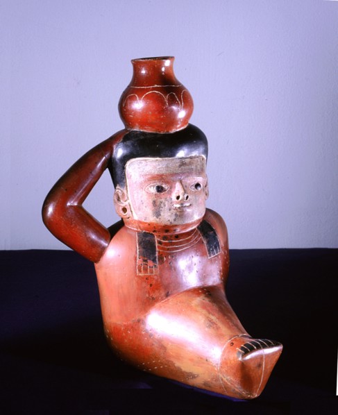 Polychrome jug in the form of a seated figure carrying a pot
