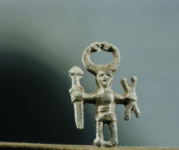 Pendant or amulet of a man holding a sword and two spears and wearing a horned helmet
