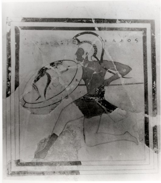 A terracotta slab painted with a running hoplite carrying a spear and shield