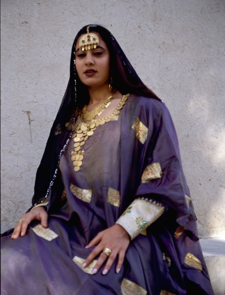 A woman wearing impressive gold jewellery and traditional costume
