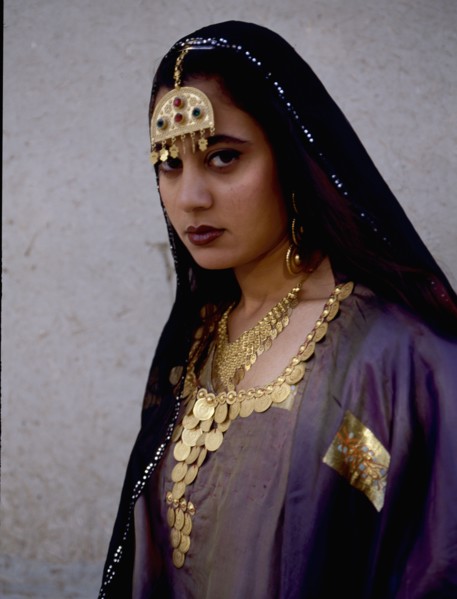 A woman wearing impressive gold jewellery and traditional costume
