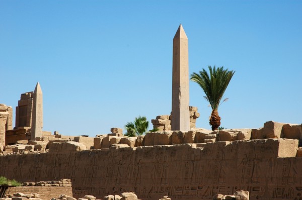 View of a hieroglyph wall and the two obelisks of Tuthmosis II (left) and Queen Hatshepsut (right) in the background