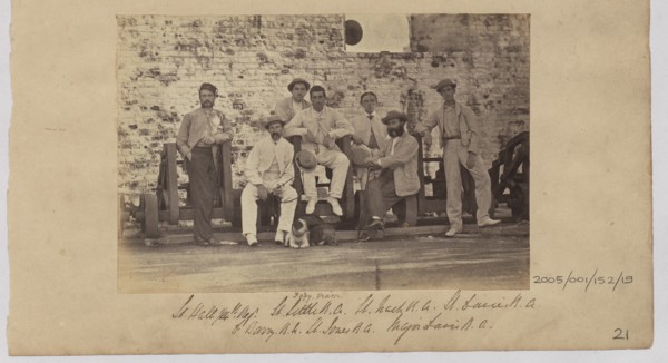 Group of men in civilian clothes pose against a wall