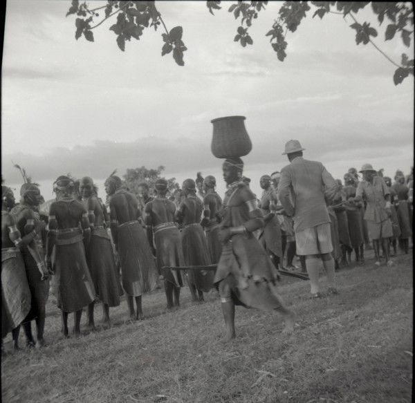 Woman going to inyangi, in front of ch. J. and dancers