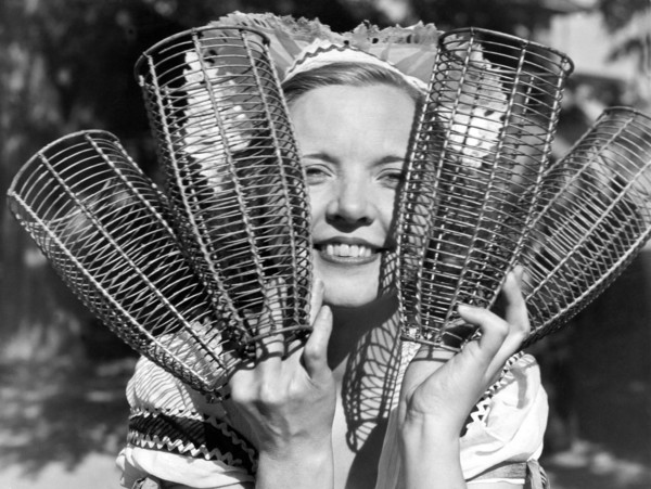 California:  c. 1934.
A woman holding up the baskets that will dress the California champagne