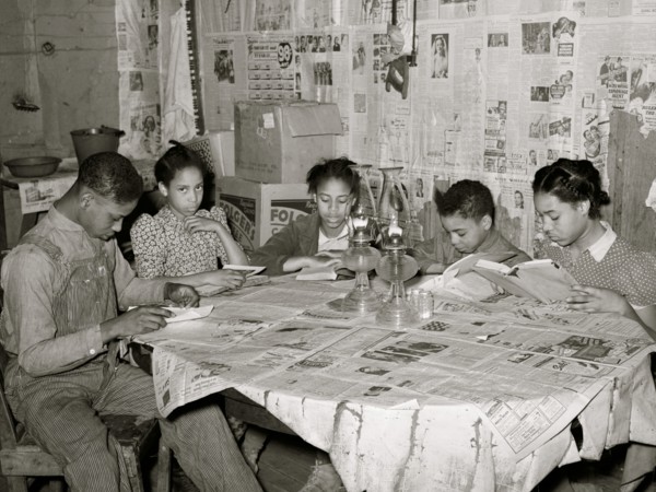Five children of Pomp Hall, Black tenant farmer, studying their lessons by lamplight. Creek County, Oklahoma. 1938
