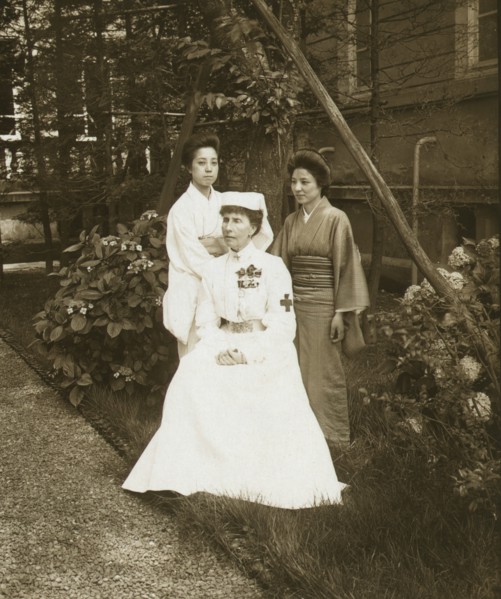 A western Red Cross female doctor and two Japanese women posed in a garden 1905