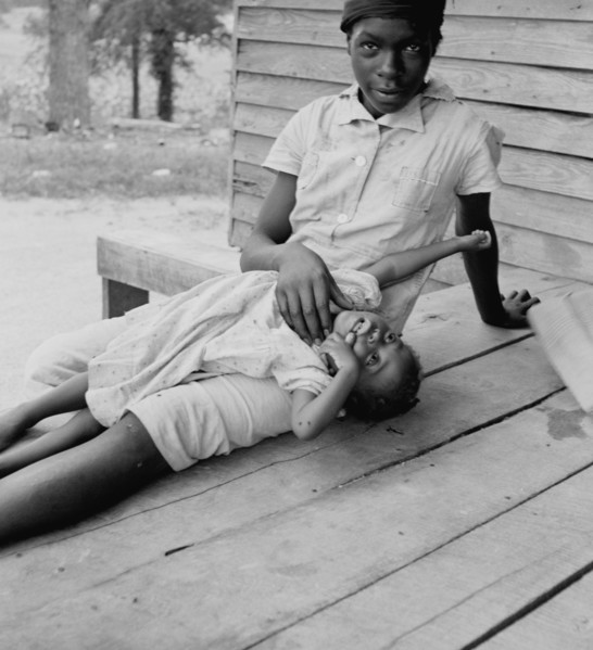 African American young girl with a small child on a porch 1939