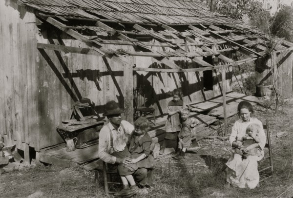 Frank Burditt and family. They rent this dilapidated shack and are trying to make a living off the meager land near by.  1921