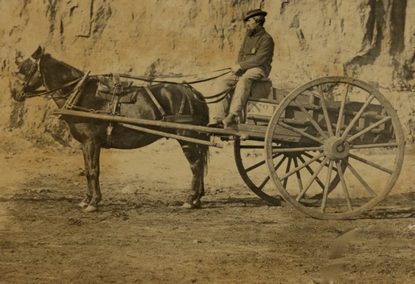 Man sitting in a horse drawn cart 1863