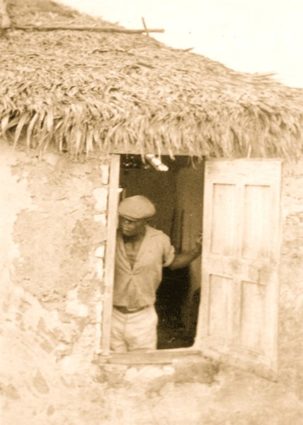Man standing at door of house, looking out, possibly from the visit by Alan Lomax and Mary Elizabeth Barnacle to Cat Island in the Bahamas 1935