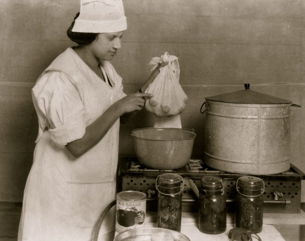 One of the Cabel County Demonstration Team demonstrating the process of blanching tomatoes to visitors at the 4 H Club Fair.  1921