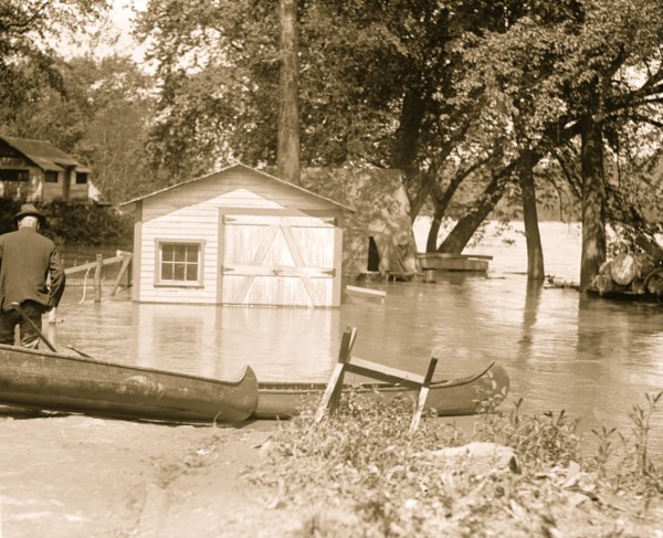 River overflows into garage; canoes set on the banks 1924