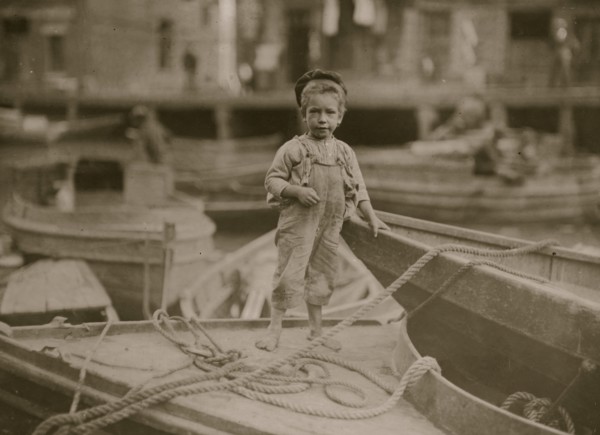 Truant hanging around boats in the harbor during school hours. 1909