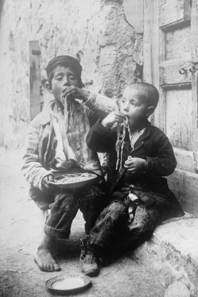 Two Neapolitan Children slurp down Spaghetti