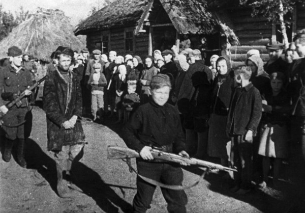 World war 2, a russian traitor being marched from the open air courtroom where he had been judged by the villagers, the procession is being led by a 13 year old guard, a full-fledged partisan scout, f...