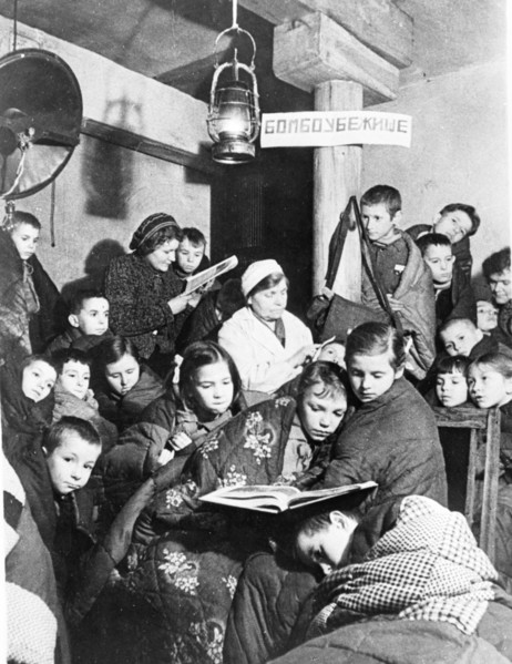 world war ll: leningrad during the blockade, during an air raid alert children take cover in the nearest bomb shelter.