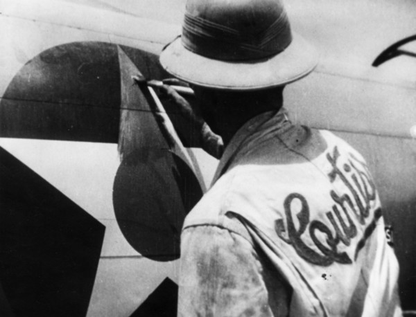 World war 2, lend-lease, a man painting out the american insignia with red paint for delivery of the plane to russia, iran.