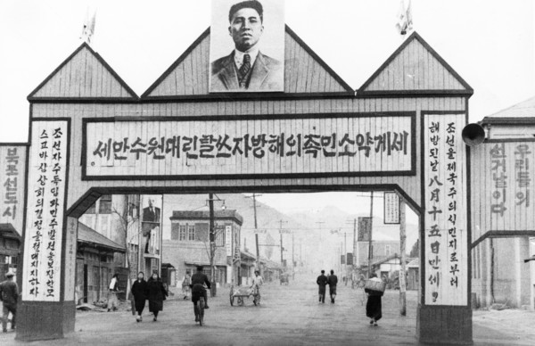 Portrait of kim il sung over a street in the town of kaishu, north korea, may 1947.