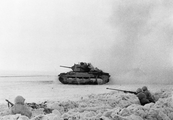 A british tank manned by red army soldiers advancing on the enemy during world war 2, an anti-tank rifle crew is in the trench (right).