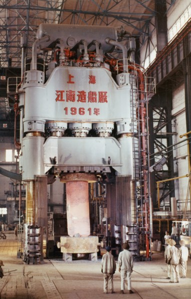 The 1,200 ton hydraulic press at the shanghai heavy plant in china in the early 1960's, it is pictured processing a 55 ton machine part of steel rolling equipment, made and designed in china, the pres...