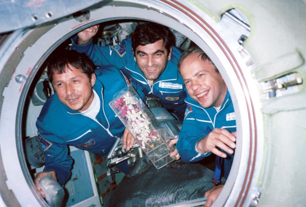 Russian cosmonauts viktor savinykh (left) and anatoly solovyov(right) and bulgarian astronaut alexander alexandrov (centre) seen pictured with orchids in the access hatch of the 'mir' space station, t...