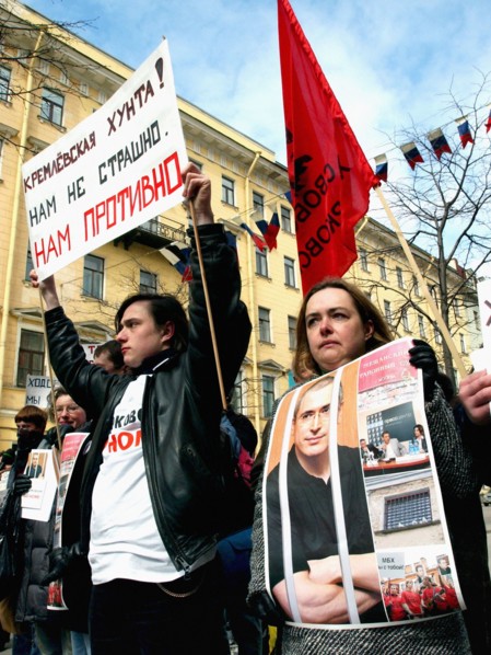 St,petersburg, russia, april 24, 2005, a participant in the action holds up a placard reading 'kremlin junta! we are not scared, we are disgusted' during an action in support of mikhail khodorkovsky, ...