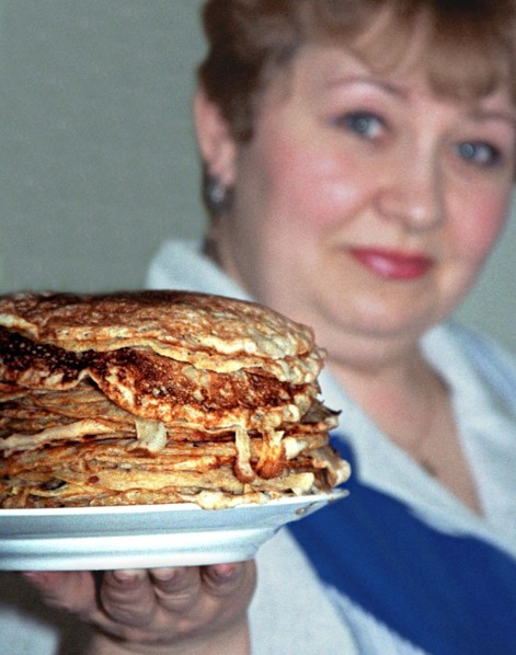 Yekaterinburg, russia, 3/13/02: yekaterina zasada, a resident of yekaterinburg, showing off a pile of bliny (pancakes) she has cooked for maslenitsa (shrovetide), which is celebrated this week, tradit...