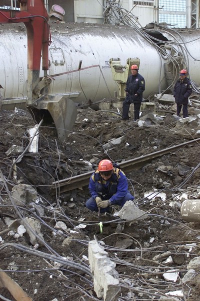 Baikonur, kazakhstan, may 14 2002: workers clearing the fragments of 'energia' rocket carrier and first russian space shuttle 'buran' from debris of the destroyed roof of the assembly and test block w...