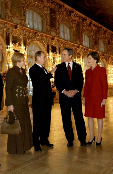 Leningrad region, russia, november 22 2002: president of russia vladimir putin (2nd l) and president of the usa george bush (2nd r) and their wives lyudmila (l) and laura (r) in one of the halls of th...