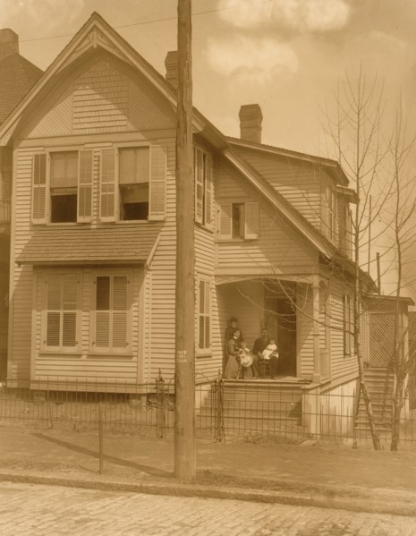 African American family posed on porch of house