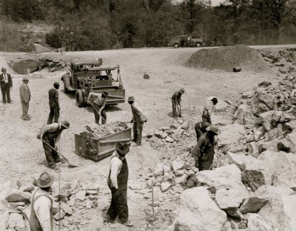 Prisoners breaking up rocks at a prison camp or road construction site