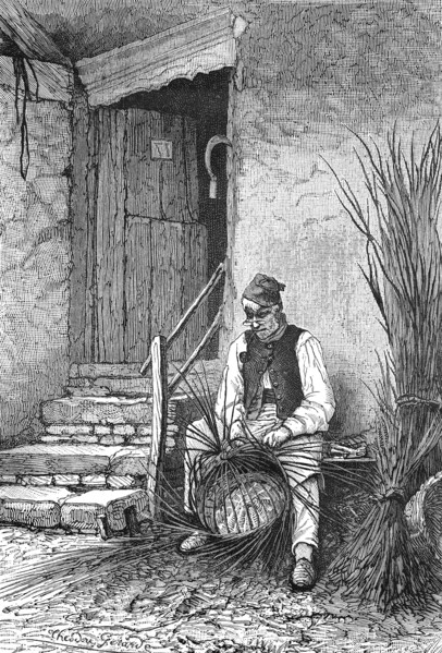 Wicker sits in front of his house and wilts a wicker basket  /  Korbflechter sitzt vor seinem Haus und flechtet einen Weidenkorb