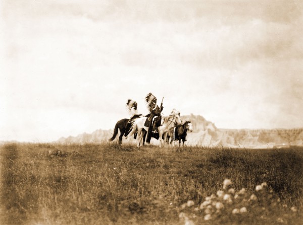 Edward S. Curits Native American Indians - Three Sioux Indians of horseback on plains with rock formation in background circa 1905.