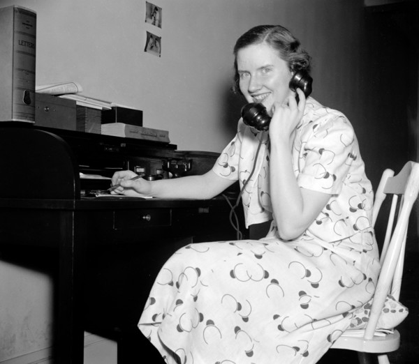 Woman using telephone circa 1937.