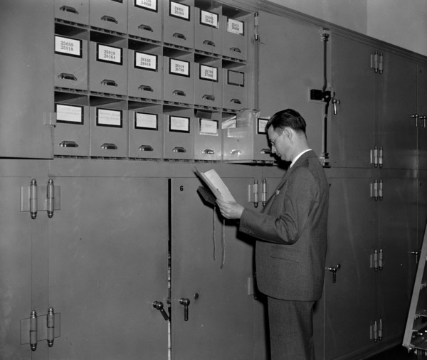 Secret Service agent at cabinet full of confiscated currency awaiting disposition, court trials, etc. circa 1938.