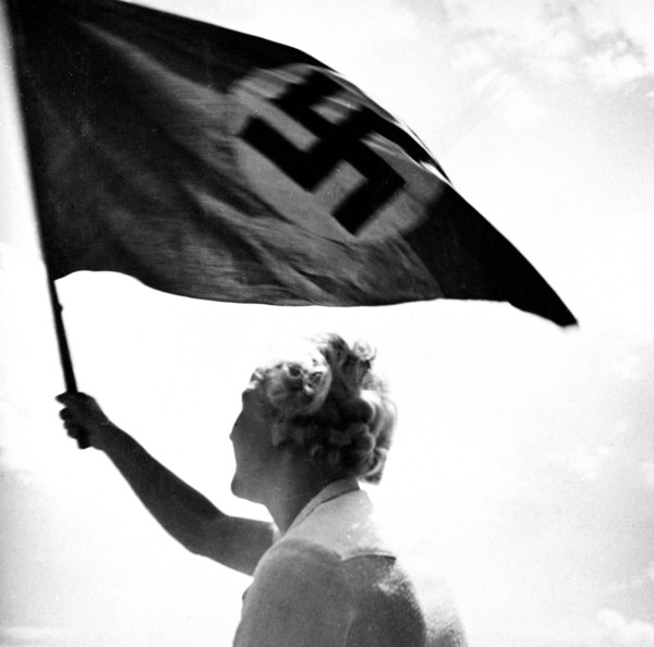 Woman waving Nazi flag circa late 1930s or early 1940s.