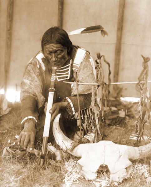 Edward S. Curtis Native American Indians - Dakota man with calumet kneeling by altar inside tipi circa 1907.