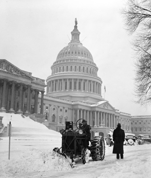 Man plowing snow with tractor on December 30, 1935 in front of the United States Capitol in winter.