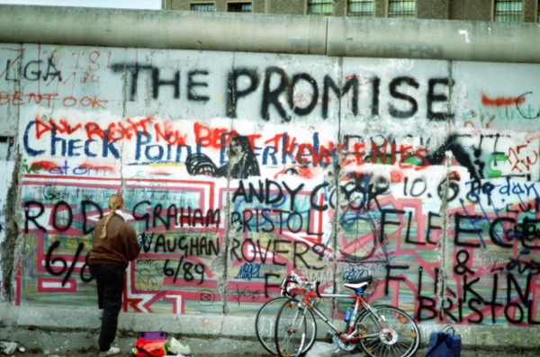 A West German woman attempts to chip off a piece of the Berlin Wall as a souvenir.   A portion of the Wall has already been demolished at Potsdamer Platz..