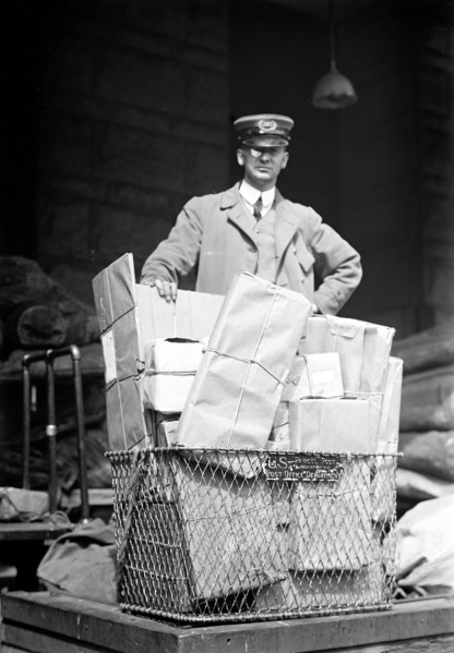 Mail man with a basket full of parcel post packages