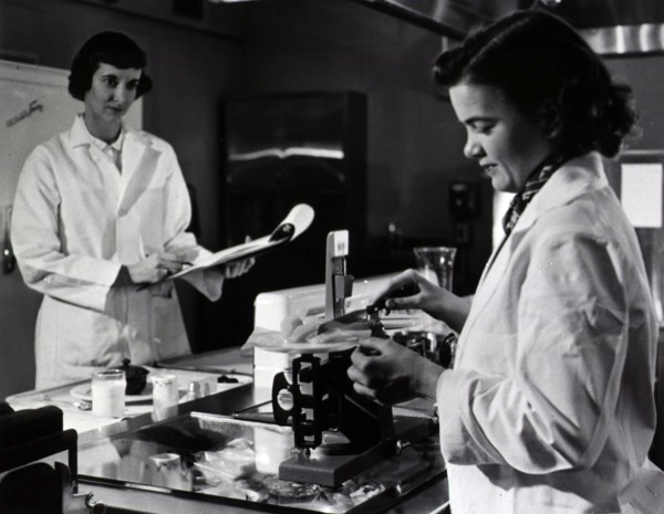 Two female dietitians weigh and measure foods before they are served to patients of restrictive diets.