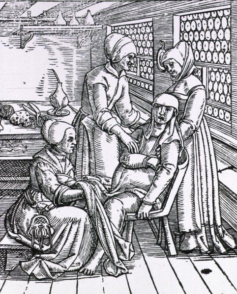 Three midwives attending to a pregnant woman