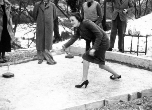 Woman playing some type of curling game outdoors