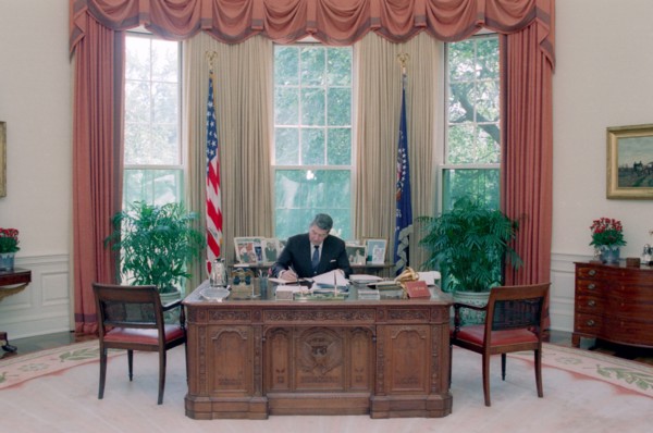 President Reagan working at his Oval Office desk.