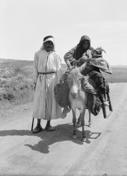 Bedouins in Israel, a woman and infant on donkey, a man standing ca. between 1934 and 1939