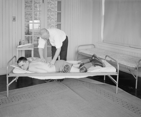 An athlete receiving a rub down by a trainer ca.  between 1910 and 1925