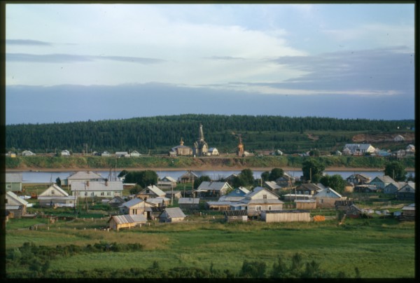Southwest view, with village on left bank of Varzuga River in foreground, and Church of the Dormition (1674), beyond river in background, Varzuga, Russia; 2001