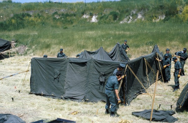 Marines erect a tent at a temporay housing facility for Vietnamese refugees.