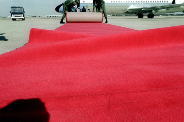 Airmen place a red carpet on the ground